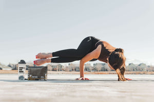 Beautiful girl doing Yoga pose with E3 Energy Cubes bars and shaker bottle.  Peanut Butter + Chocolate.  Gluten-free, Dairy-free, Soy-free, Non-gmo, All natural protein bars.